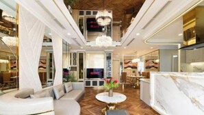 A modern hotel lobby with a central seating area, a chandelier, and a TV screen displaying 'NETFLIX'. - VINHOMES CENTRAL PARK LUXURY APARTMENT (Ho Chi Minh City)