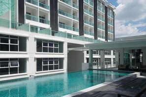 A modern hotel with a swimming pool, multiple floors, and a glass facade. - Damas Mont Kiara by Scape Stay (Kuala Lumpur)