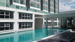 A modern hotel with a swimming pool, multiple balconies, and a clear sky. - Damas Mont Kiara by Scape Stay (Kuala Lumpur)