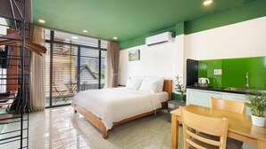 Una habitación de hotel moderna con cama, una mesa de comedor y una kitchenette.