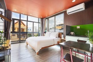 A modern hotel room with a large bed, a dining table, and a kitchenette. - Gemini Saigon Center - New & Quiet Near Bui Vien Walking Street (Ho Chi Minh City)