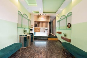 A reception area with a reception desk, seating, and a staircase leading to an upper level. - Gemini Saigon Center - New & Quiet Near Bui Vien Walking Street (Ho Chi Minh City)
