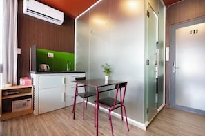 A compact kitchenette with a small table and chair, a green backsplash, and a potted plant. - Gemini Saigon Center - New & Quiet Near Bui Vien Walking Street (Ho Chi Minh City)