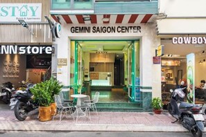 Een hotelentree met een bordje met de tekst 'Gemini Saigon Center'.