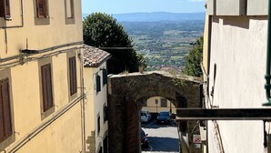 A narrow street with a stone archway leading to a parking area. - City / Village Apartment in Cortona with 1 bedrooms sleeps 2 (Cortona)
