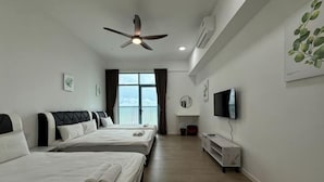 Une chambre d’hôtel avec deux lits, un ventilateur de plafond, une télévision et un balcon avec vue.