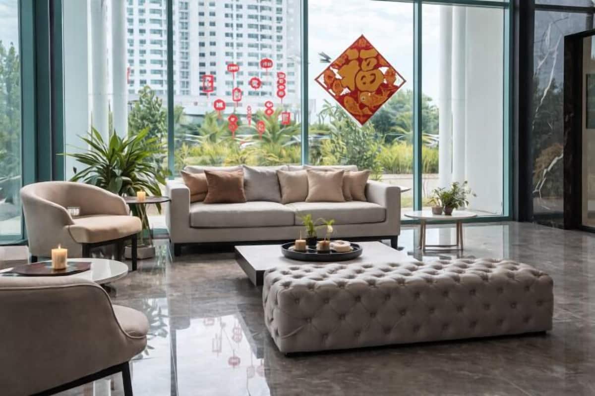 A modern living room with a sofa, armchair, ottoman, and a coffee table.