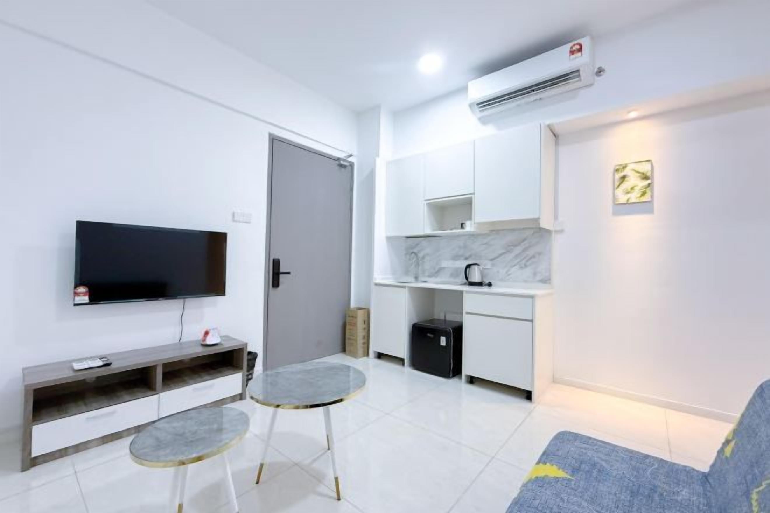 A modern living room with a flat-screen TV, a sofa, and a small dining table.