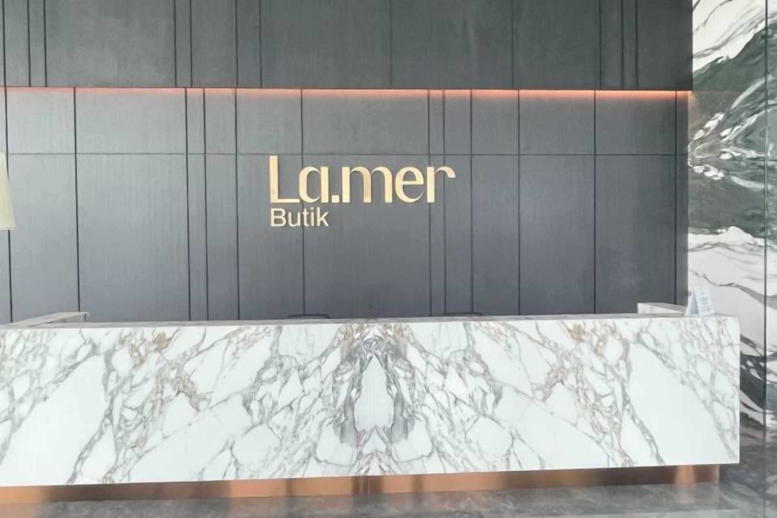 A reception desk with a marble top and a dark panel background.
