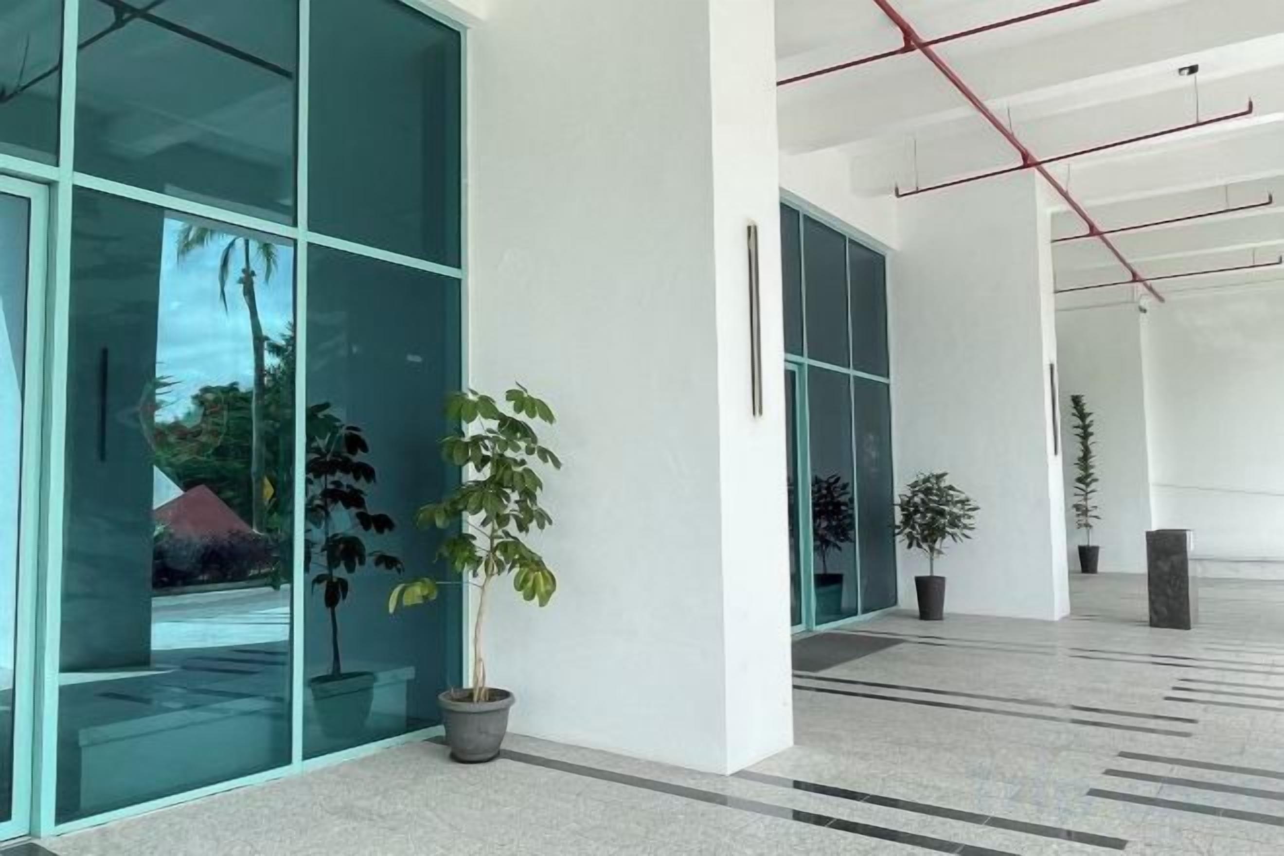 A modern building interior with large glass windows, potted plants, and a clean, minimalist design.