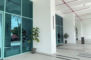 A modern building interior with large glass windows, potted plants, and a clean, minimalist design. - Baysuites Near Sicc (Kota Kinabalu)