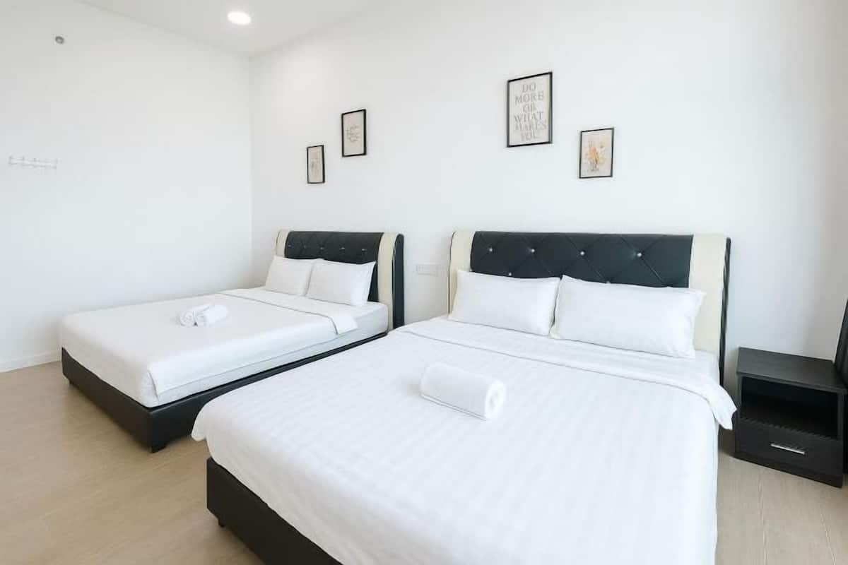 A hotel room with two beds, a small bedside table, and a wall-mounted shelf.