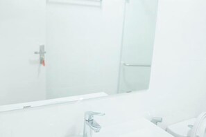 Une salle de bain avec un miroir, un lavabo et des toilettes.