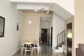 A spacious living area with a dining table and chairs, a staircase, and a door leading to another room. - LestariHome2, KLIA Sepang (Sepang)