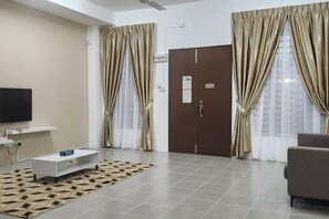 A modern living room with a flat-screen TV, a sofa, a coffee table, and a patterned rug. - LestariHome2, KLIA Sepang (Sepang)