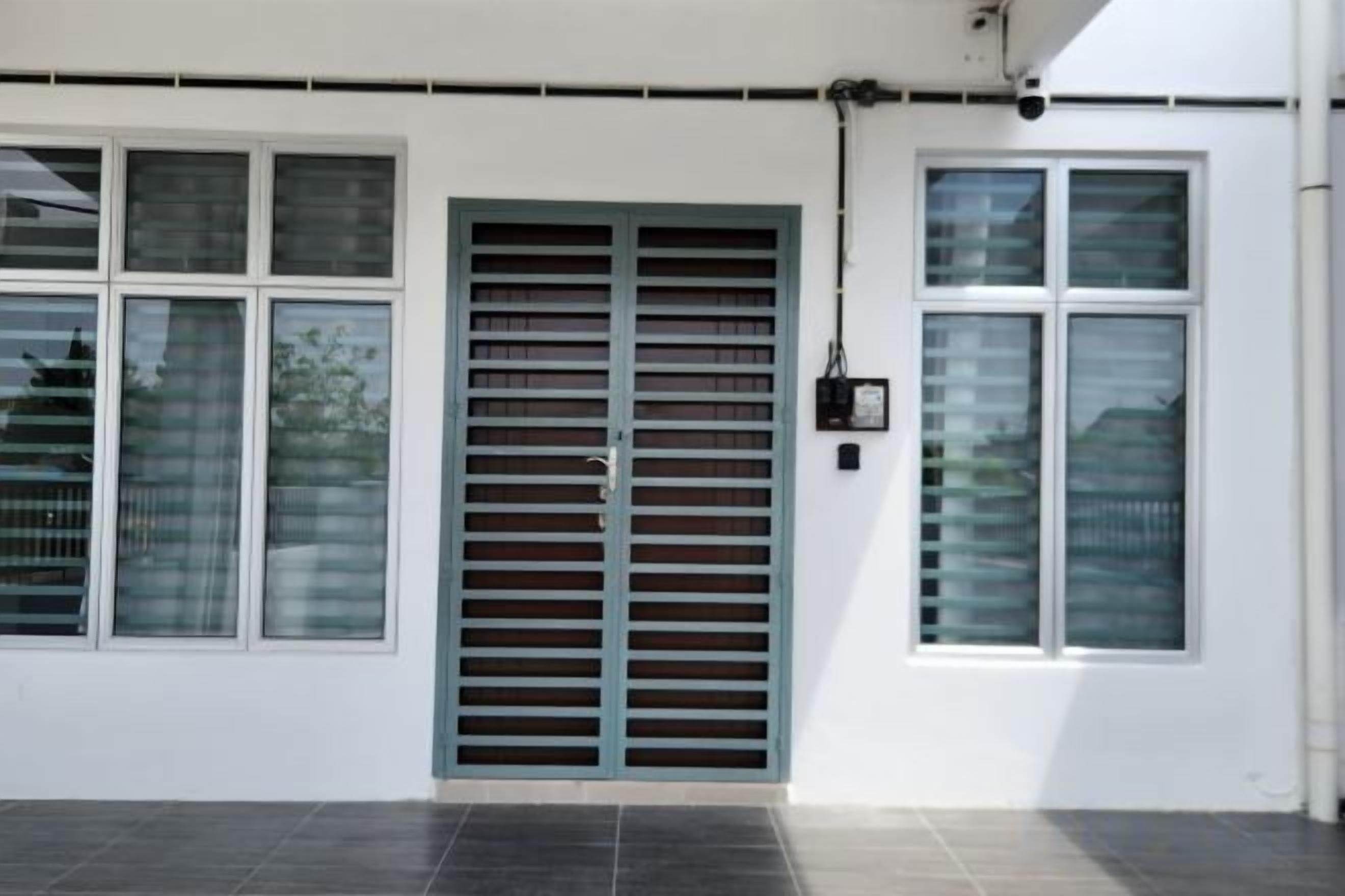 A building exterior with a large metal gate, multiple windows, and a clean, white facade.