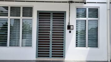 A building exterior with a large metal gate, multiple windows, and a clean, white facade.