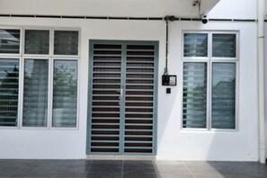 A building exterior with a large metal gate, multiple windows, and a clean, white facade. - LestariHome2, KLIA Sepang (Sepang)