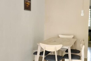 A dining area with a table and chairs, a wall-mounted light switch, and a framed picture. - LestariHome2, KLIA Sepang (Sepang)