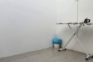 A corner of a room with a metal folding chair, a blue trash bin, and a white wall. - LestariHome2, KLIA Sepang (Sepang)