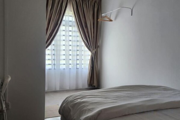 A bedroom with a bed, a window with curtains, and a hanging light fixture. - LestariHome2, KLIA Sepang (Sepang)