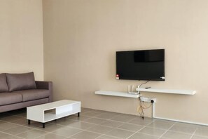A modern living room with a flat-screen TV mounted on the wall, a white coffee table, and a brown sofa. - LestariHome2, KLIA Sepang (Sepang)