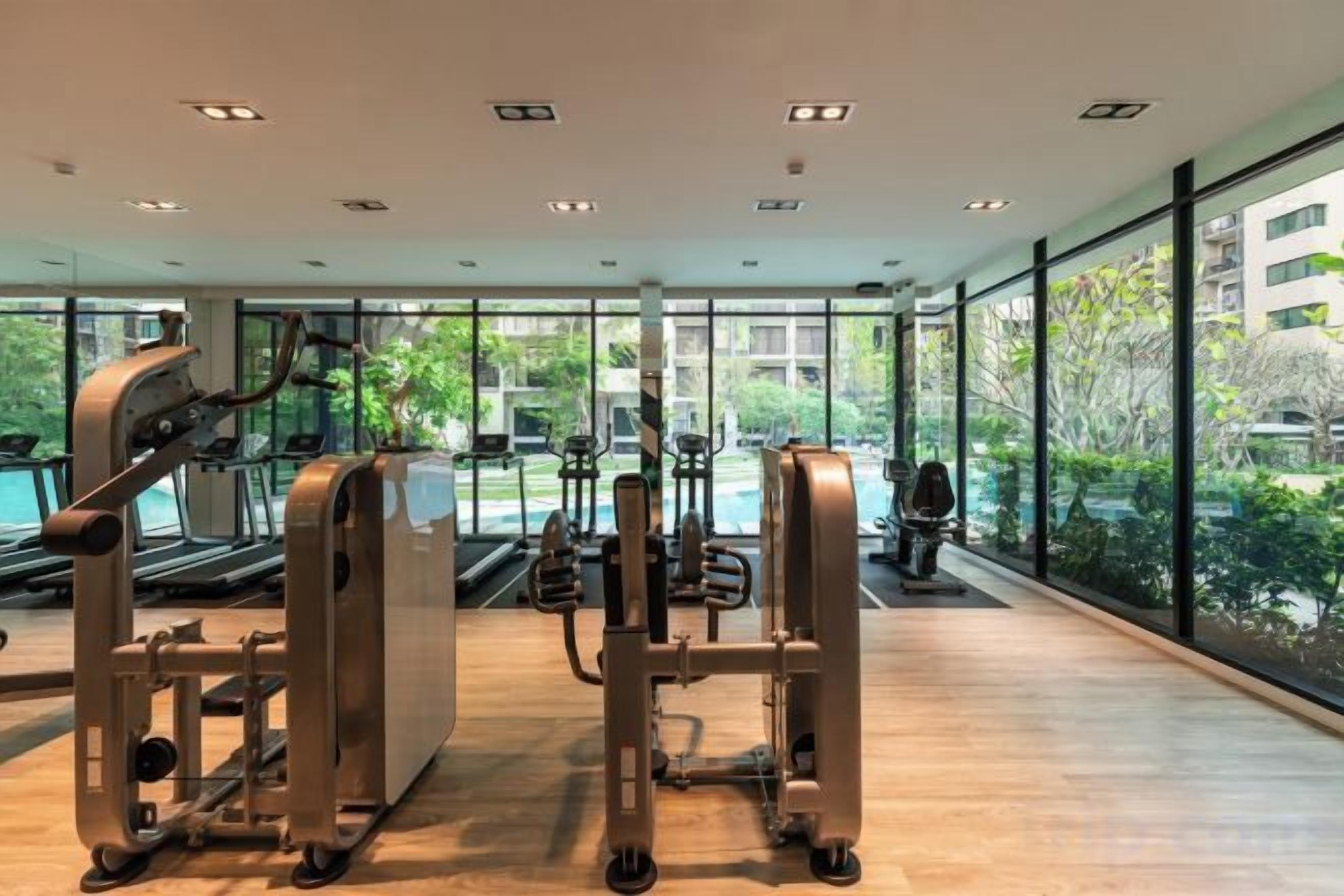 A gym with cardio machines, free weights, and a treadmill.