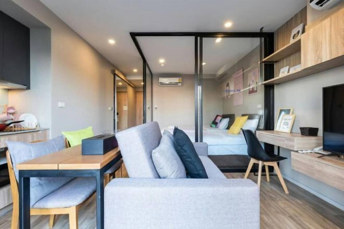 Una sala de estar moderna con un sofá, una mesa de comedor y una televisión.