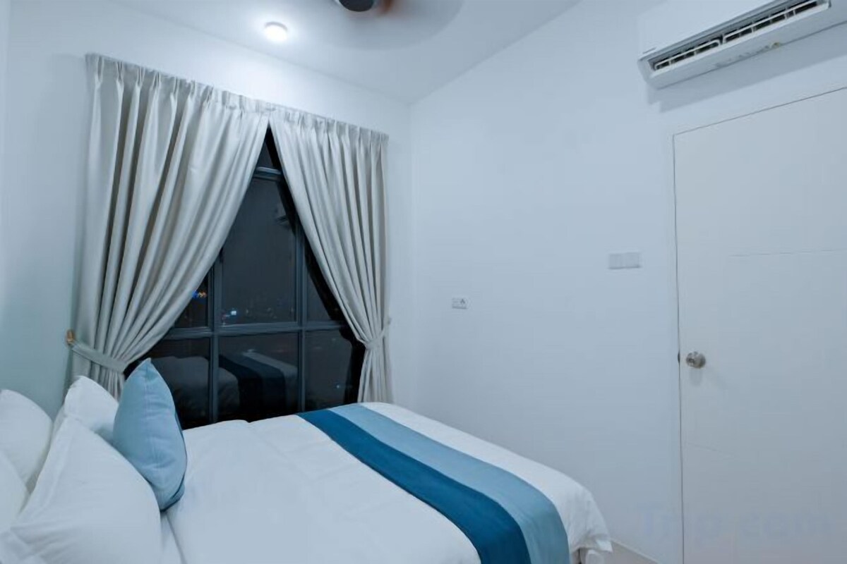 Une chambre d’hôtel avec un lit, une fenêtre avec des rideaux, une porte et un appareil de climatisation.