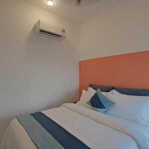 A hotel room with a bed, pillows, a blanket, an air conditioning unit, and a ceiling light. - G Residence Sky Suite (Alor Setar)