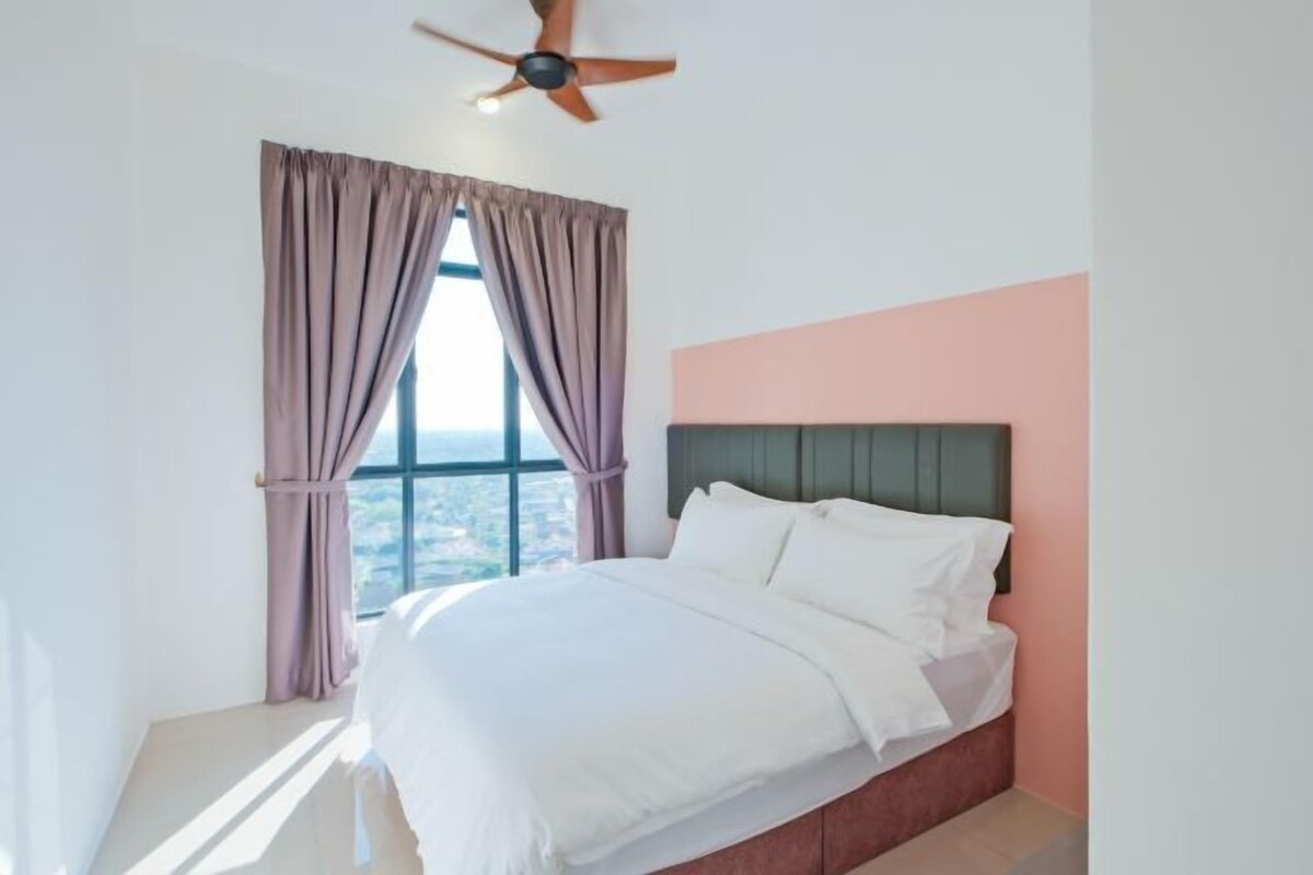 A bedroom with a bed, curtains, a ceiling fan, and a window with a view.