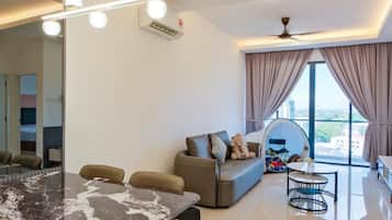 A modern living room with a dining area, a sofa, a ceiling fan, and a large window with curtains.