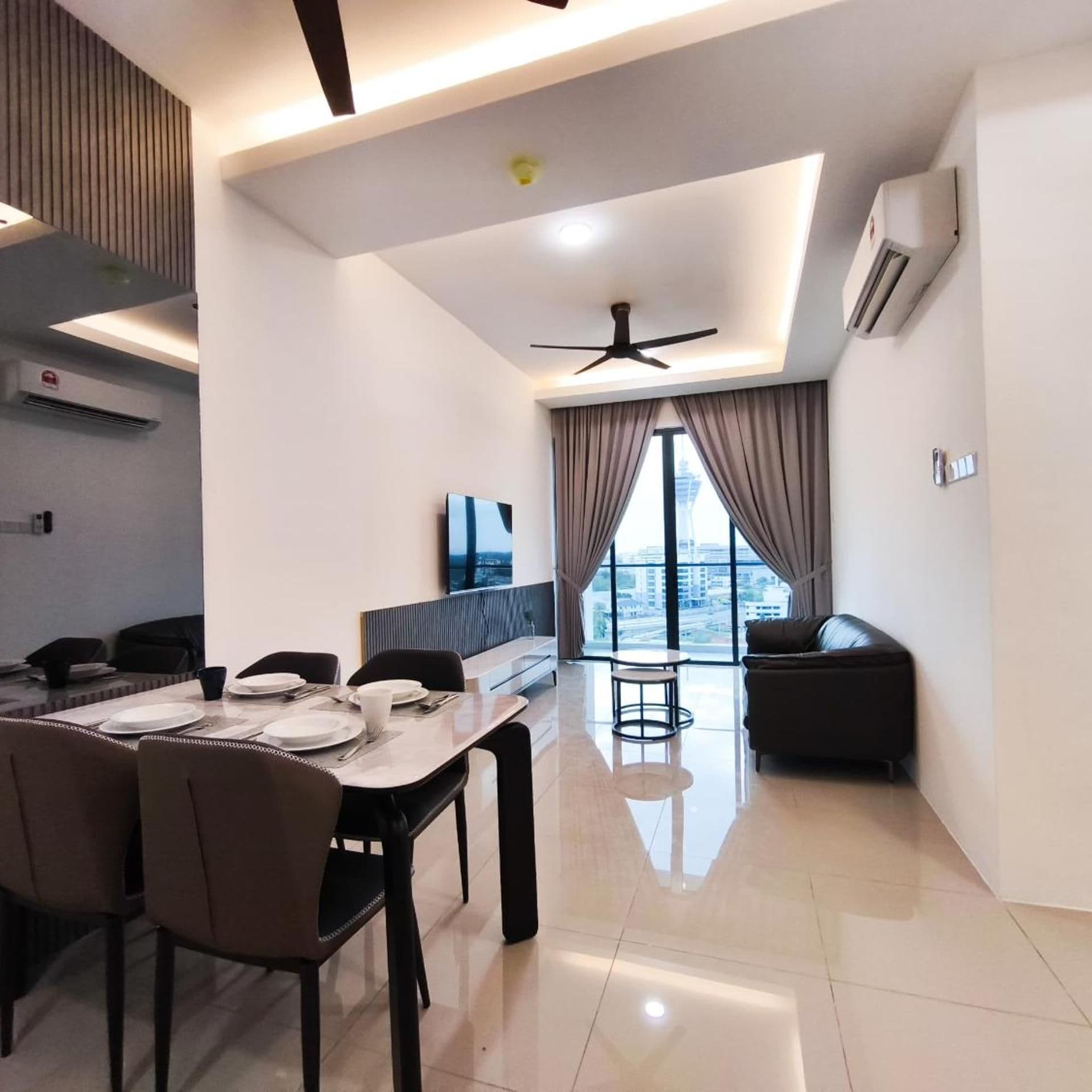 Una sala moderna con comedor, ventilador de techo y un amplio ventanal con cortinas.