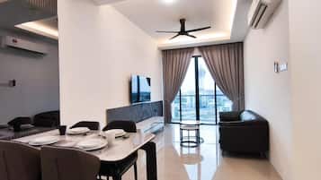 Una sala moderna con comedor, ventilador de techo y un amplio ventanal con cortinas.