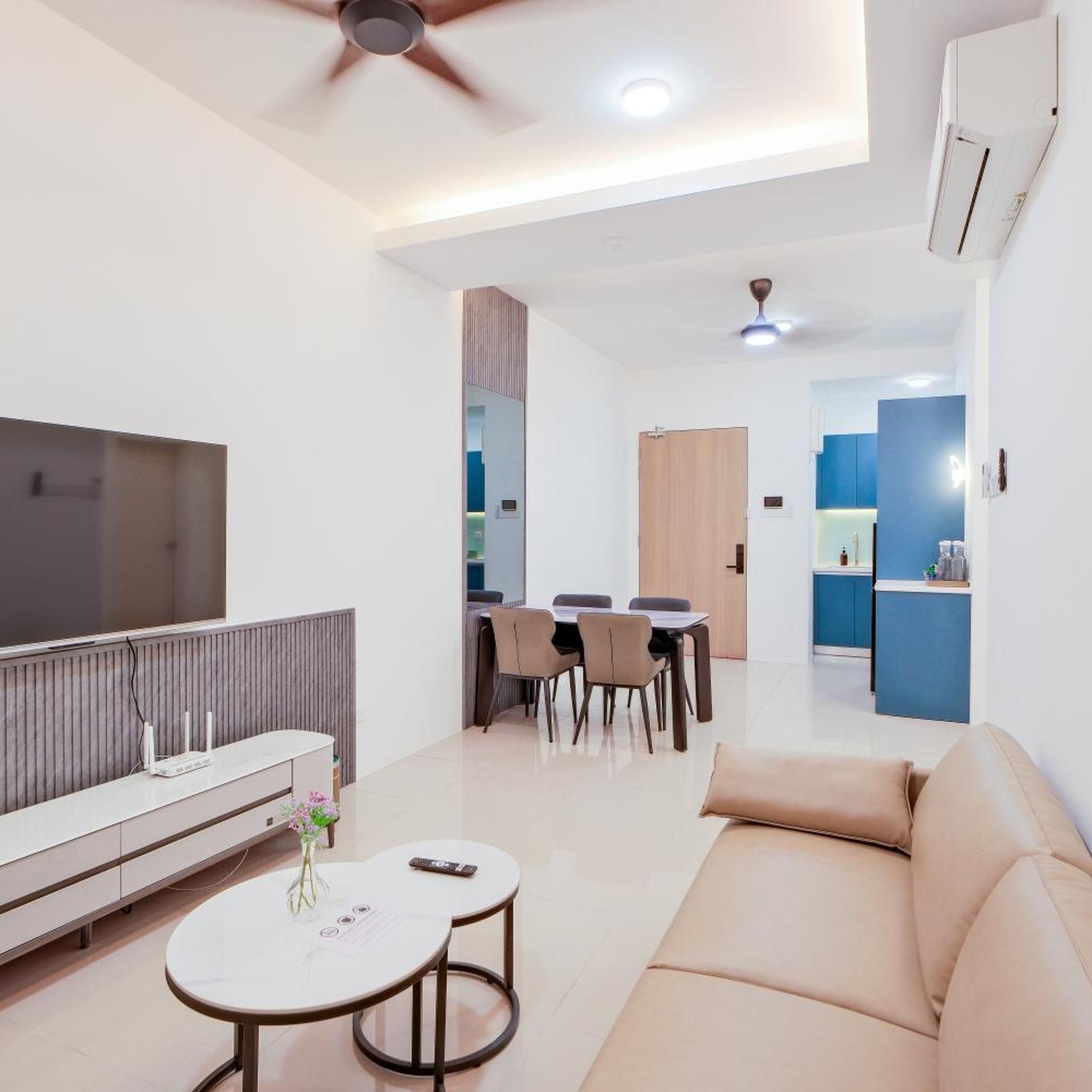 Una sala de estar moderna con un sofá, un televisor, un comedor y una cocina al fondo.