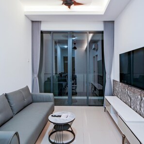 A modern living room with a sofa, a coffee table, and a TV. - G Residence Sky Suite (Alor Setar)
