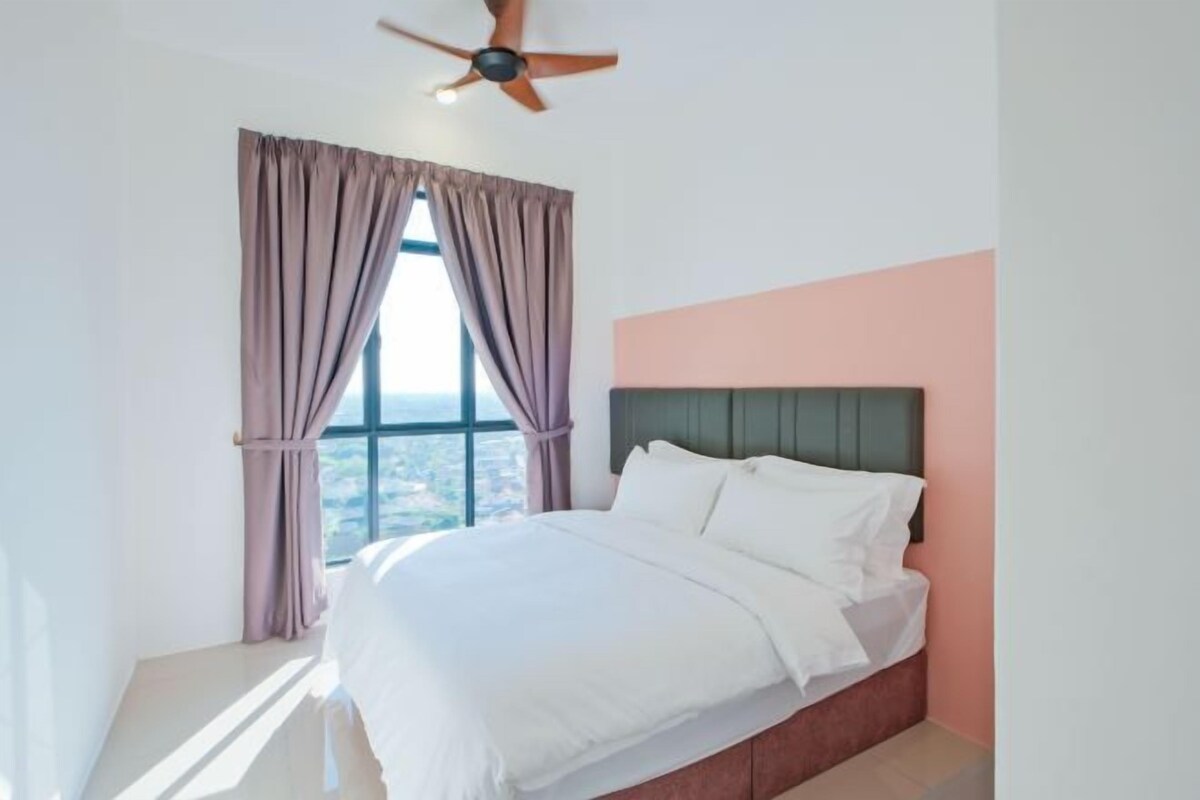 A bedroom with a bed, a window with curtains, a ceiling fan, and a view of the outside.