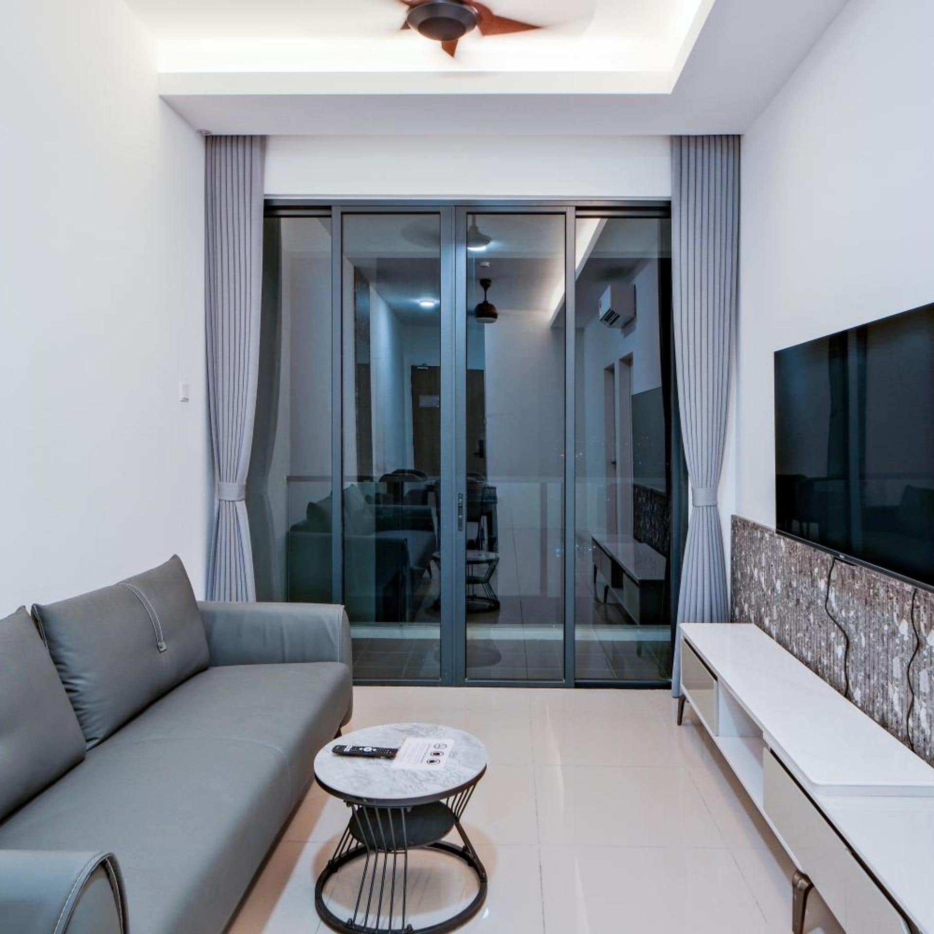 A modern living room with a sofa, a coffee table, and a TV.