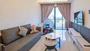 A modern living room with a sofa, a small table, a tent, and a balcony with curtains. - G Residence Sky Suite (Alor Setar)
