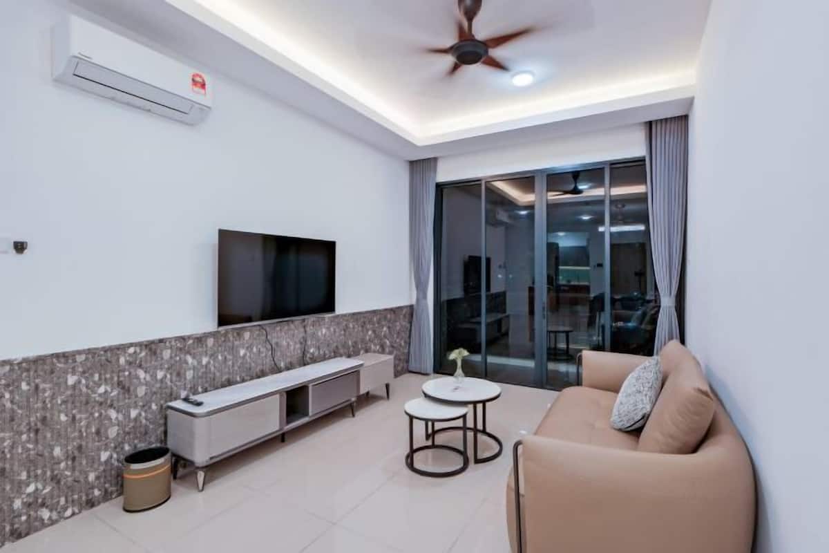 A modern living room with a flat-screen TV, a sofa, a coffee table, and a ceiling fan.
