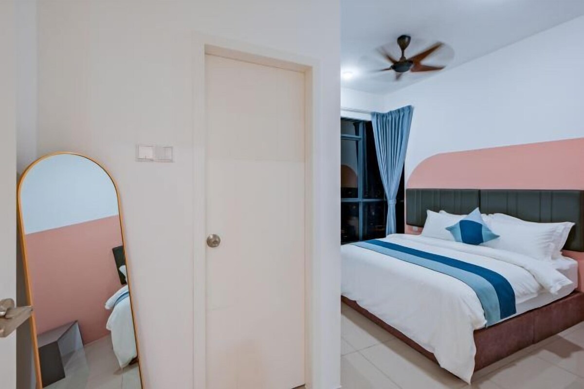 A bedroom with a bed, a ceiling fan, and a door.