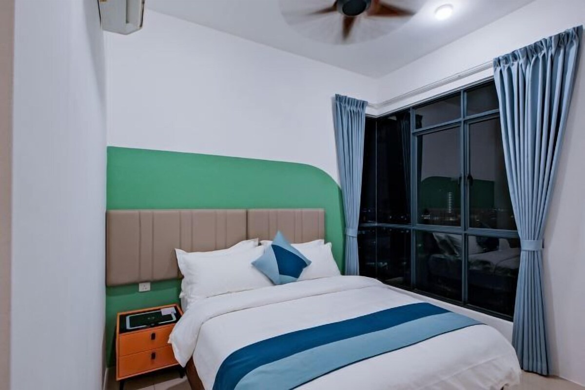A bedroom with a bed, nightstand, and window with curtains.