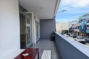 A balcony with a bench and a door leading to an interior space. - Shoreline Guesthouse (Semporna)