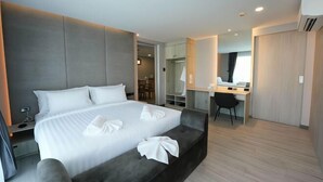 Une chambre d’hôtel moderne avec un grand lit, un bureau et un dressing.