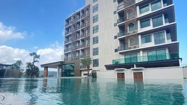 Un hôtel à plusieurs étages avec une piscine située à l’avant.