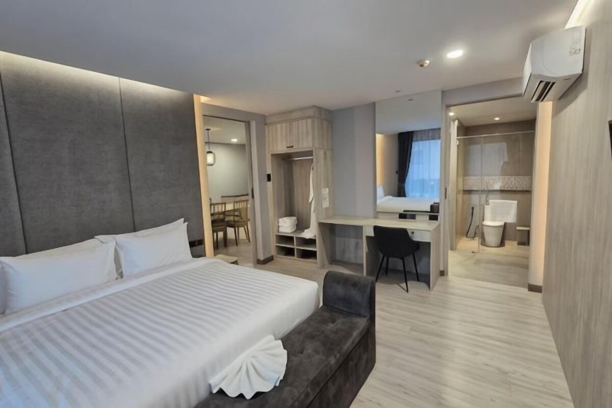 Ein Hotelzimmer mit einem großen Bett, einem Schreibtisch, einem Stuhl und einem Kleiderschrank.