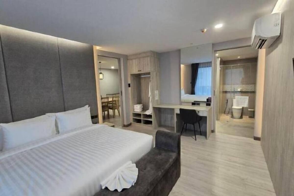 Une chambre d’hôtel moderne équipée d’un grand lit, d’un bureau, d’une chaise et d’un petit coin salon.