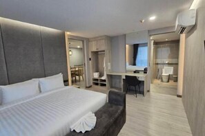 A modern hotel room with a large bed, a desk, a chair, and a small seating area. - Aura Hotel Hatyai Songkhla (Hat Yai)