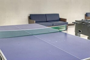 A ping pong table with a sofa and a foosball table in the background. - L. Casa • Tagaytay Staycation (Tagaytay)