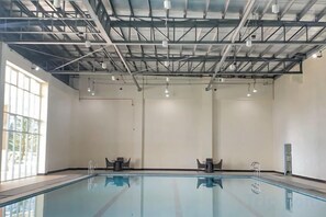 An indoor swimming pool with a high ceiling, large windows, and a clean, modern design. - L. Casa • Tagaytay Staycation (Tagaytay)